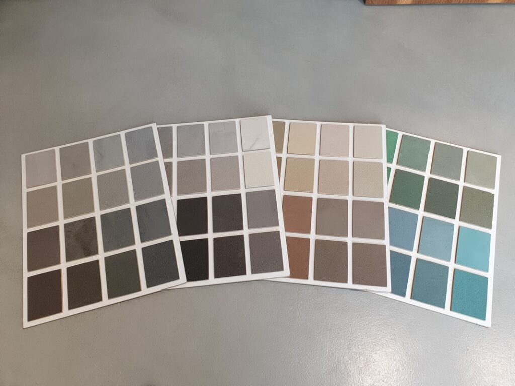Pr&oacute;bki materiałowe prezentujące r&oacute;żne kolory mikrocementu ułożone w zestawach kolorystycznych. Paleta kolor&oacute;w mikrocementu pokazuje możliwości dopasowania odcieni do r&oacute;żnych styl&oacute;w wnętrz.