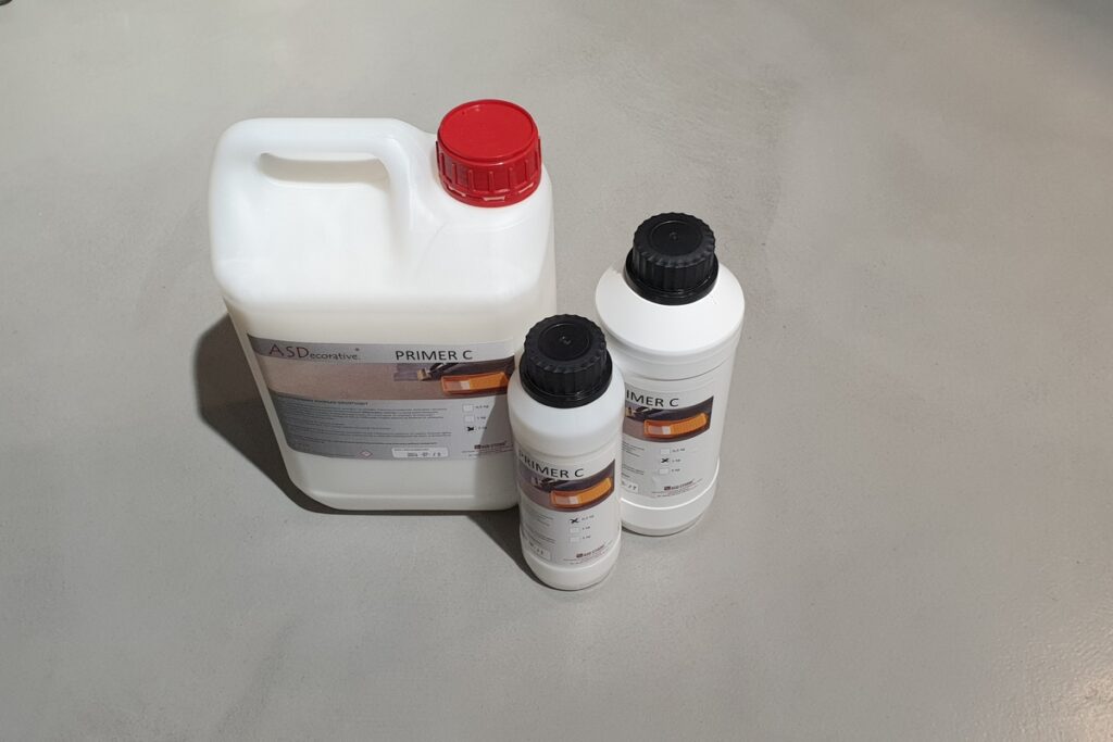 Preparat gruntujący PRIMER C pokazany jako niezbędny element przygotowania podłoża. Gruntowanie ułatwia trwałe wykonanie mikrocementu na podłodze i poprawia przyczepność warstw.