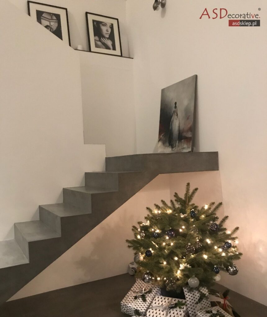 Ujęcie schod&oacute;w w trakcie realizacji, z widocznymi stopniami i pionowymi podstopnicami. Schody z mikrocementu tworzą sp&oacute;jną, gładką bryłę bez fug oraz łączeń charakterystycznych dla płytek.