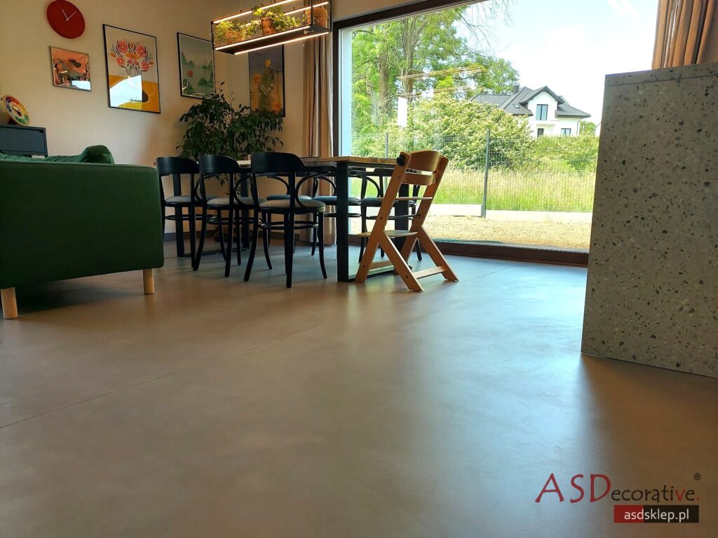 Mikrocement we wnętrzu pokazuje bezfugową powierzchnię na dużej ścianie i podłodze, co jest wybierane wtedy, gdy chcesz uzyskać jednolity efekt i łatwiejsze sprzątanie bez fug.