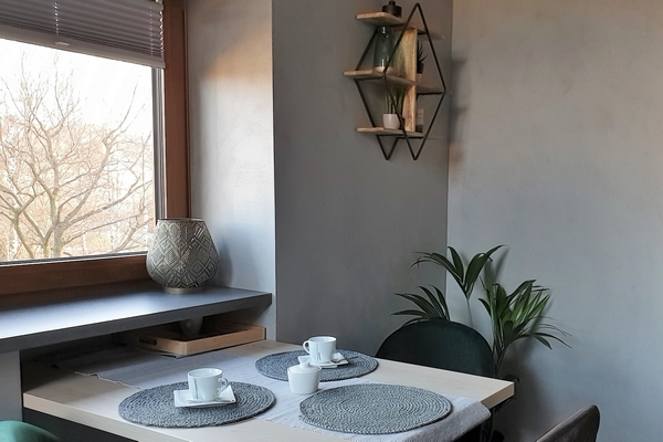 Ściana we wnętrzu mieszkalnym wykończona mikrocementem o jednolitej strukturze i naturalnym kolorze. Przykład estetycznego zastosowania mikrocementu w nowoczesnej aranżacji wnętrz.