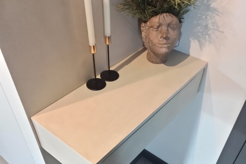 Meble łazienkowe pokryte mikrocementem z widoczną jednolitą powierzchnią blatu i front&oacute;w. Mikrocement na meblach w łazience zapewnia sp&oacute;jność ze ścianami i podłogą.