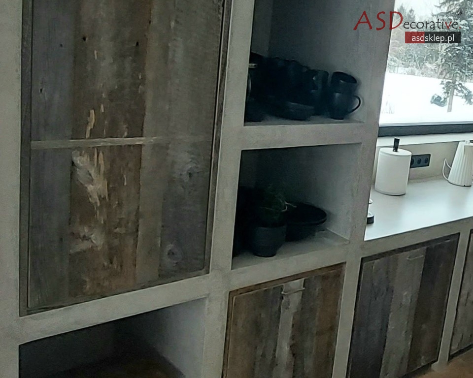 Etap szlifowania powierzchni mebla pokrytego mikrocementem w trakcie realizacji. Ten proces wpływa na końcową strukturę i wygląd mebli z mikrocementu.