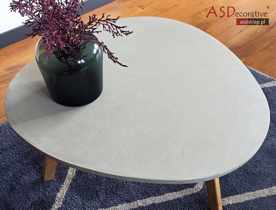 Fragment mebla po aplikacji mikrocementu, przygotowany do dalszego zabezpieczenia. Mikrocement na meblach tworzy cienkowarstwową, dekoracyjną okładzinę.